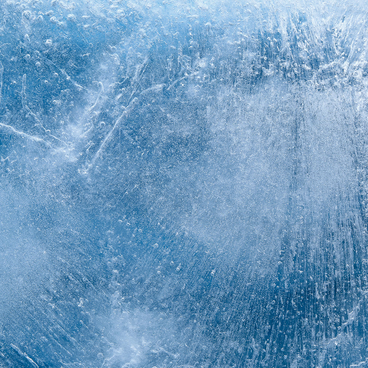 Blue ice texture with frozen air bubbles and crystalline cracks